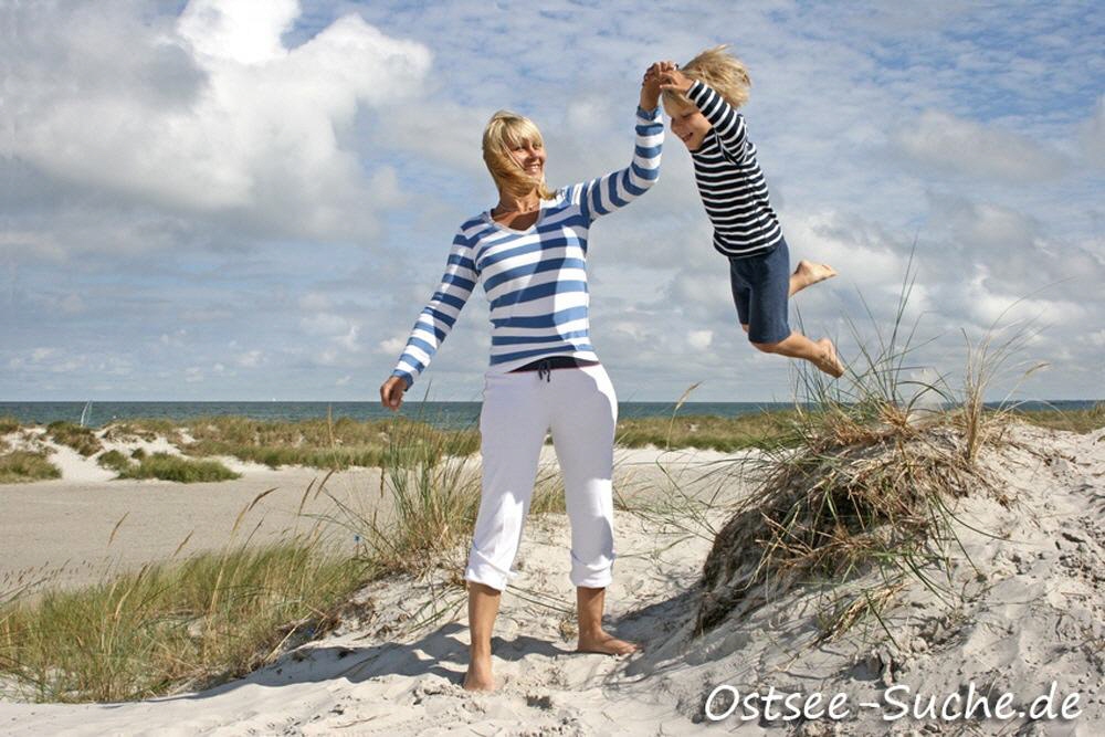 Frau spielt mit Kind am Ostseestrand