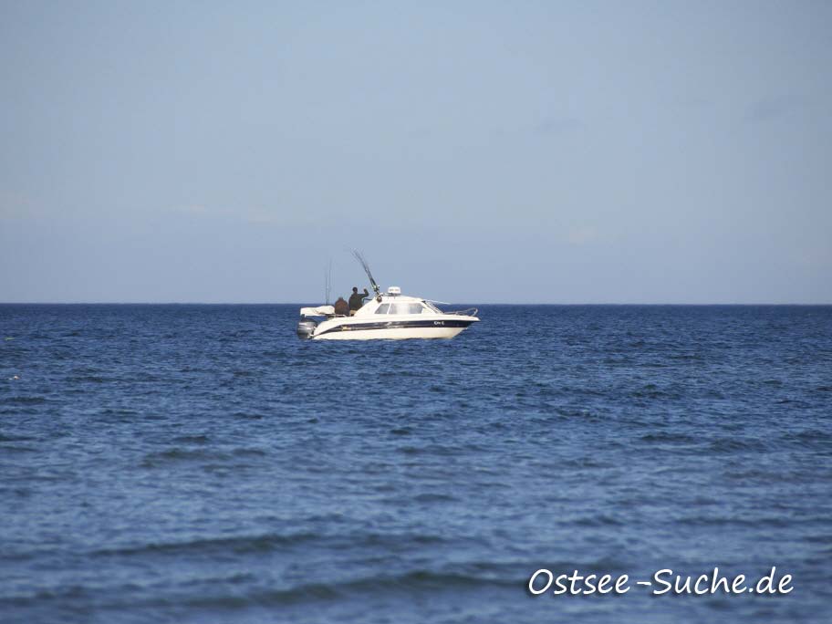 Angelbot beim Angeln vor Dahme weißes Motorboot mit mehrern ausgeworfenen Angeln vor Dahme